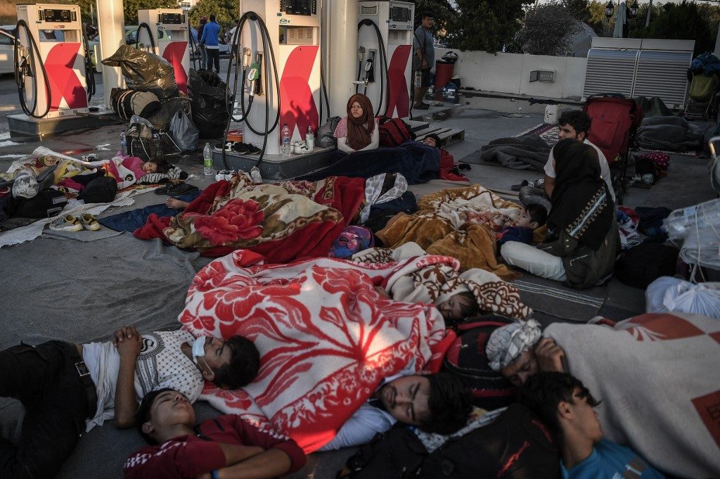 Migrants still homeless after Greek fire as police boost presence