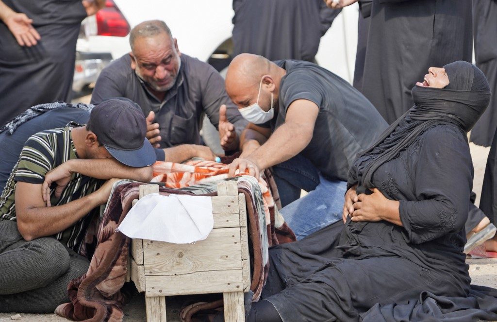Iraqis dig up coronavirus dead to rebury in family graves