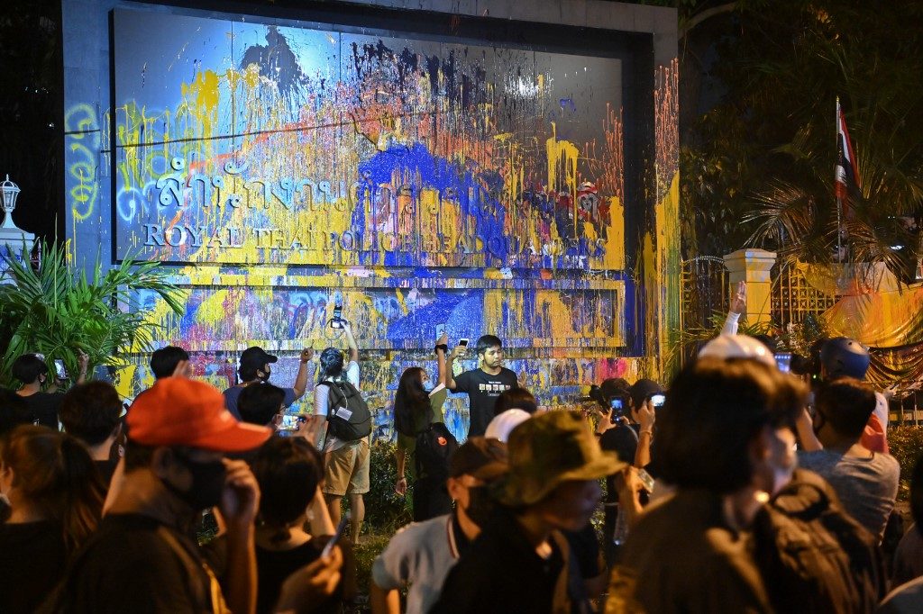 Thai protesters hit police HQ with paint, projectiles