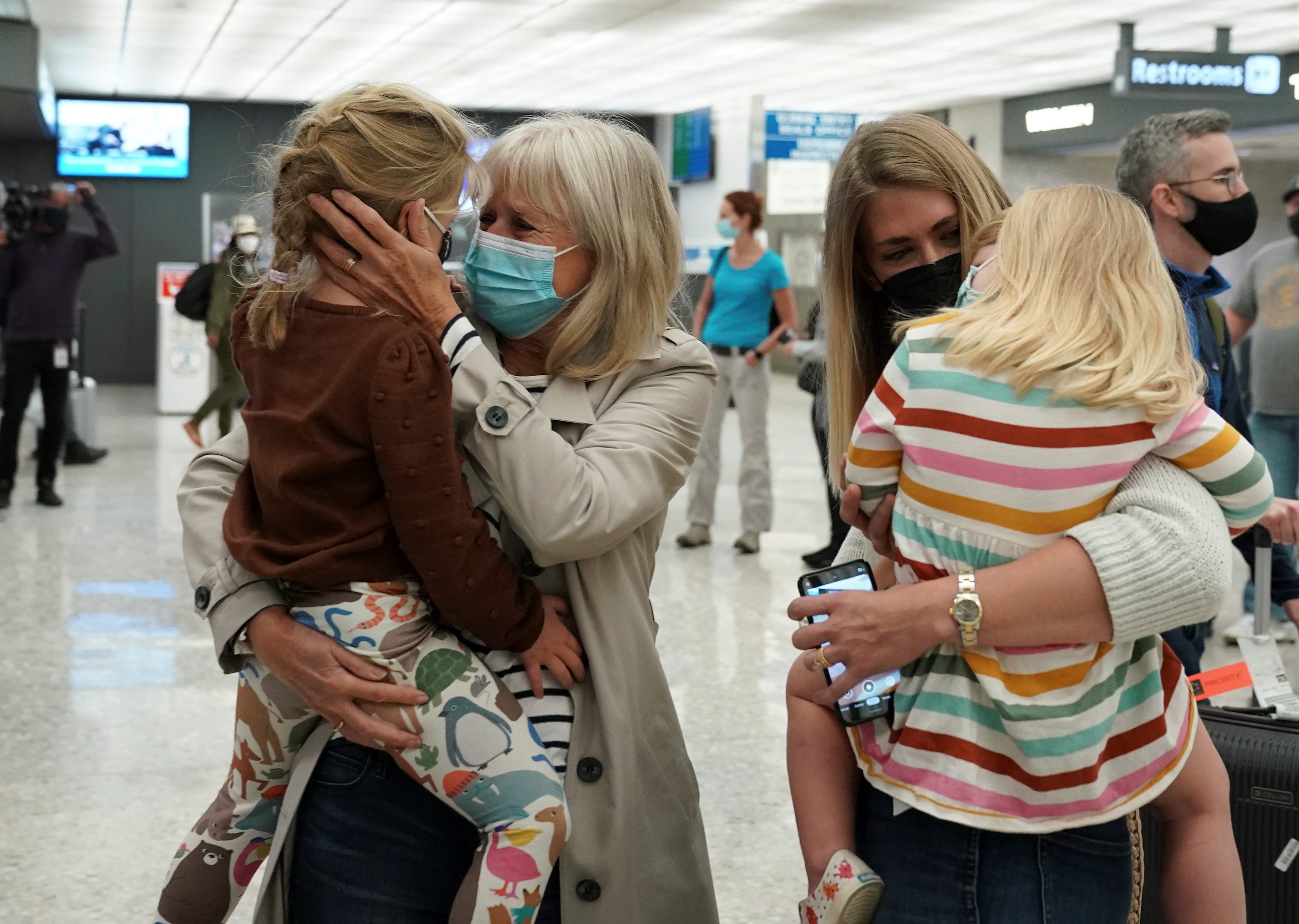 Families reunite in US with tears, balloons as COVID-19 travel ban ends