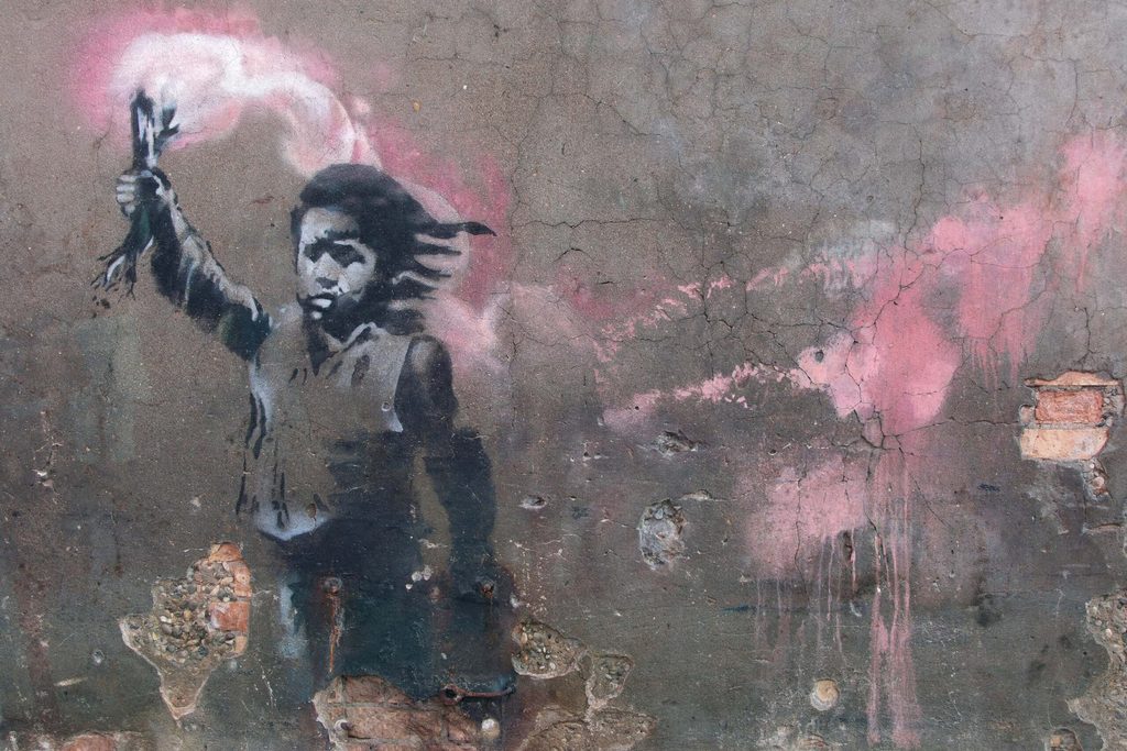 Newly restored mural attributed to Banksy depicting a migrant child wearing a lifejacket and holding a pink flare is presented in Venice