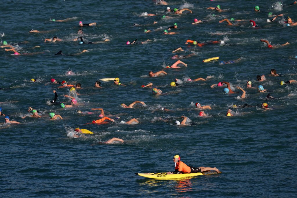 Swimmers participate in a community swim at Coogee Beach after a recent shark attack