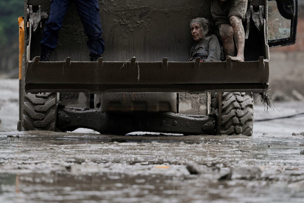 A survivor is transported to a safer place in heavy machinery following a flash flood at Trishuli, Nepal