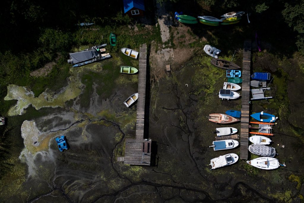 Drone view shows boats stranded in mud at a marina during a heatwave as low water levels expose the bottom of the Sulejow Reservoir in Barkowice
