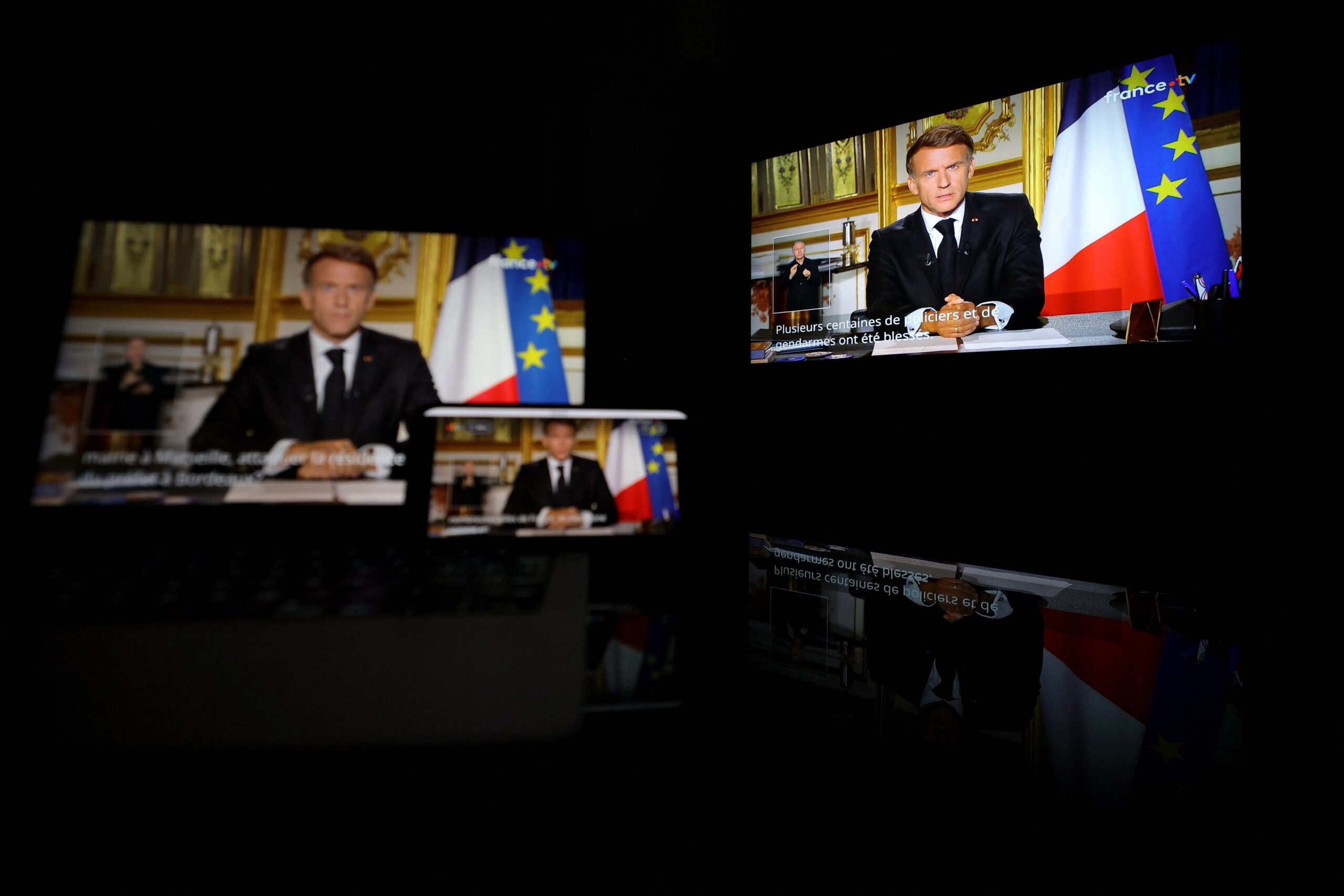 French President Emmanuel Macron appears on screen as he makes a television address to the nation a day after clashes during a national day of demonstrations against the cost of living and rising fuel prices, near Marseille, France, October 18, 2026