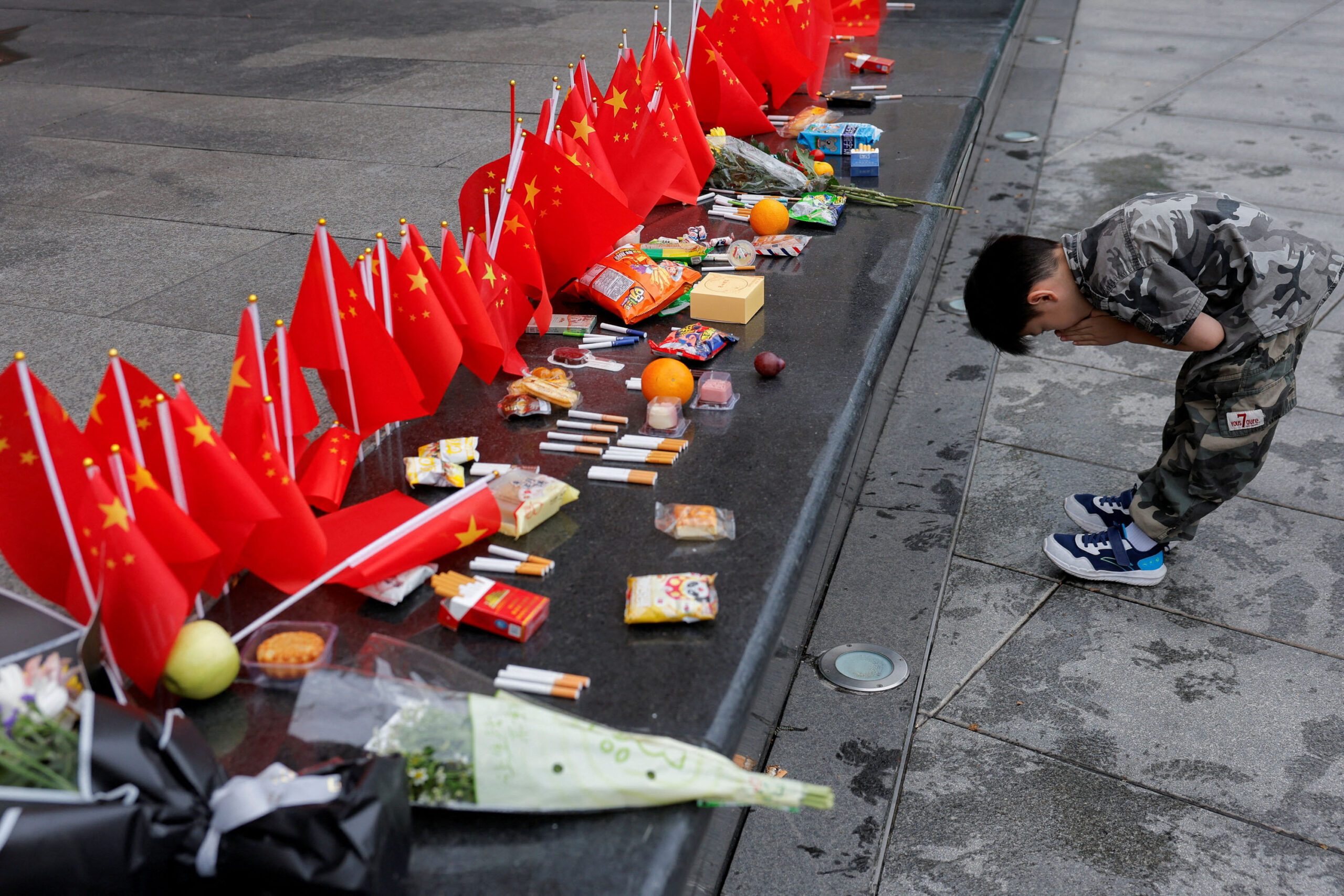 A child prays outside the Sihang Warehouse Battle Memorial on National Day in Shanghai