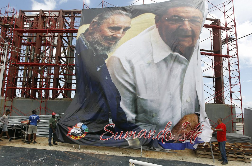 BROTHERS. Workers unfurl a giant banner with an image of Cuban President Raul Castro (R) with his brother and leader of the Cuban revolution Fidel, who turns 90 on August 13, in Havana, Cuba, August 12, 2016. Photo by Ernesto Mastrascusa/EPA 