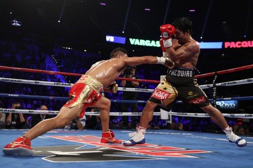 LONG REACH. Jessie Vargas throws a right to the body of Manny Pacquiao. Christian Petersen/Getty Images/AFP  