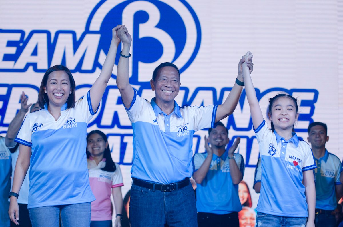 Jojo Binay, the family patriarch, raises the hands of his daughter Abby Binay and his granddaughter Martina during Abby's proclamation rally on March 29, 2019. Photo by Rob Reyes/Rappler   