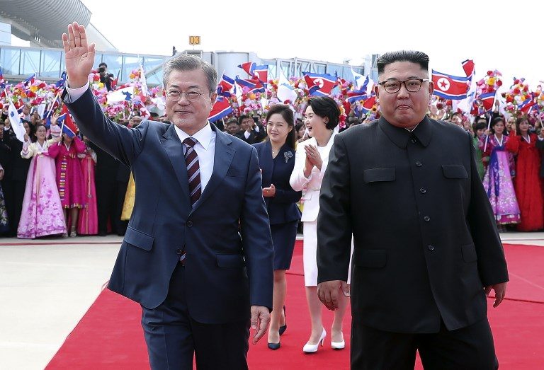 WHEN IN NORTH. South Korean President Moon Jae-in (L) waves as North Korean leader Kim Jong-un (R) looks on during a welcoming ceremony at Pyongyang airport on September 18, 2018. AFP PHOTO/Pyeongyang Press Corps  