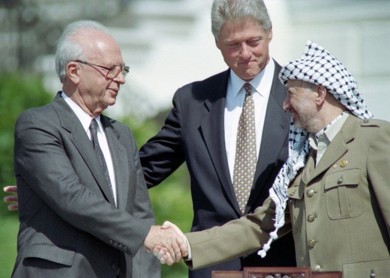 WITNESS. US President Bill Clinton (C) stands between PLO leader Yasser Arafat (R) and Israeli Prime Minister Yitzahk Rabin (L) as they shake hands for the first time, on September 13, 1993 at the White House in Washington DC, after signing the historic Israel-PLO Oslo Accords on Palestinian autonomy in the occupied territories. File photo by J. David Ake/AFP   