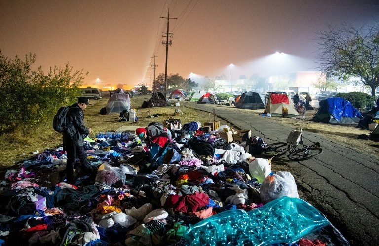 'HOME'. Evacuees sift through a pile of clothing at an evacuee encampment in a Walmart parking lot in Chico, California on November 17, 2018. Photo by Josh Edelson/ AFP  