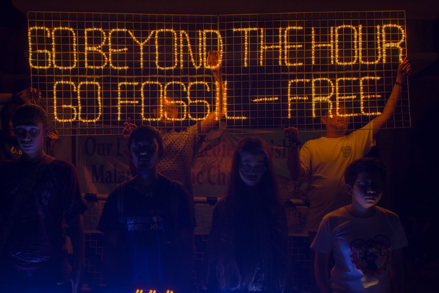 SAVE THE ENVIRONMENT. Climate activists from 350.org Pilipinas, light up LED banners at Malate Catholic Church. Photo by Maria Tan/Rappler 