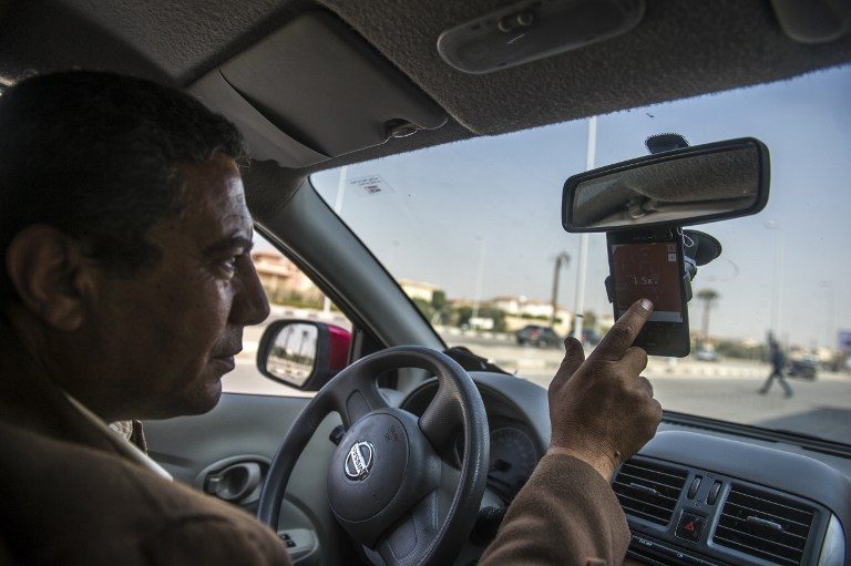 SOURCE OF LIVELIHOOD. 53-year-old Ahmed Mahmoud, an Egyptian driver working for Uber, checks a map on his phone on February 23, 2016 in Cairo, Egypt. Photo by Khaled Desouki/AFP   