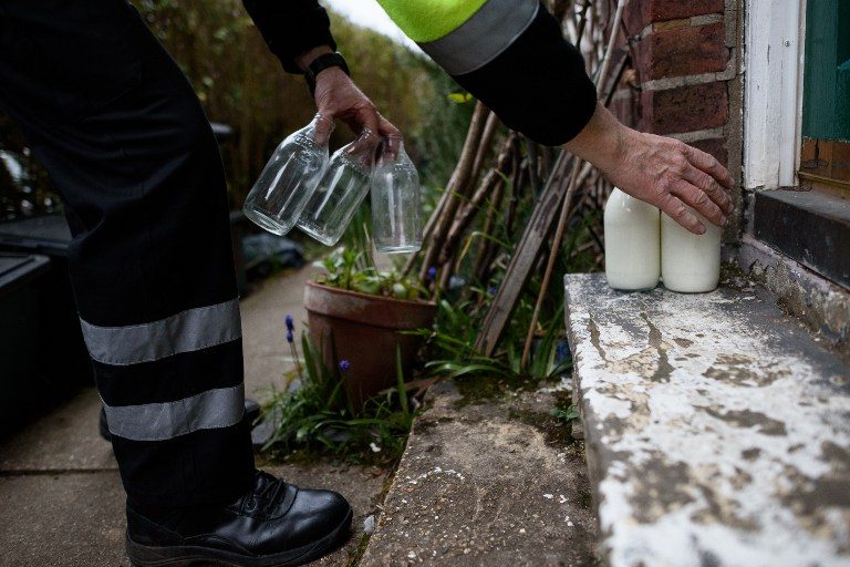 TRUSTY DELIVERY. Milkman Neil Garner sets down bottles of fresh milk for a customer on March 23, 2016. Photo by Leon Neal/AFP 