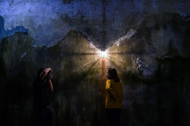 ARTIST TALK. Visitors take photos as they interact with Chinese artist Cao Fei's 'Prison Architect' installation piece at the Tai Kwun arts center in Hong Kong on November 29, 2018. Photo by Anthony Wallace/AFP   