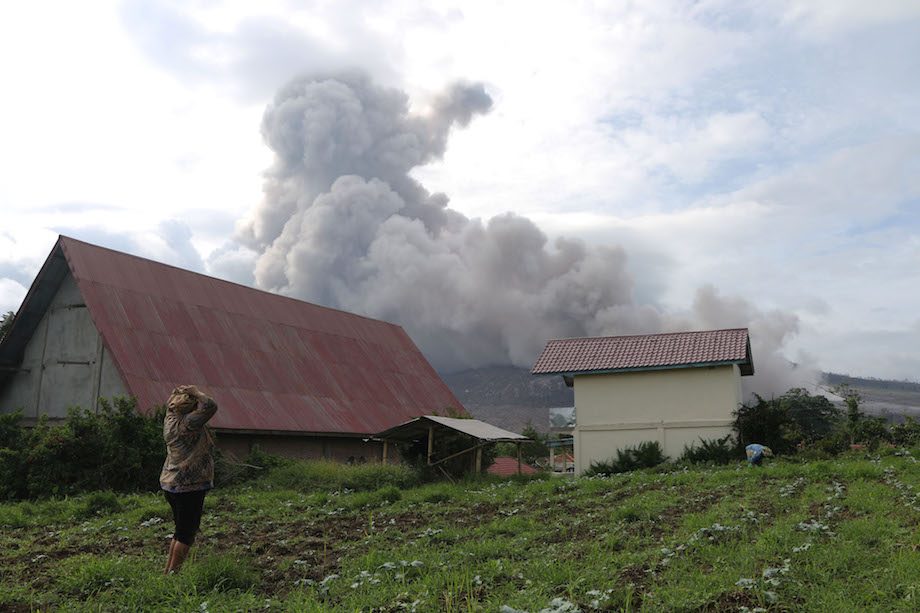 RUMAH PETANI. Petani melihat Gunung Sinabung mengeluarkan material vulkanis disertai awan panas ketika erupsi, tampak dari Desa Tiga Serangkai, Karo, Sumatera Utara, Minggu (15/11). Gunung Sinabung masih berstatus Awas (Level IV) sejak 2 Juni 2015 dan sedikitnya 7.000 warga masih mengungsi. ANTARA/Irsan Mulyadi 