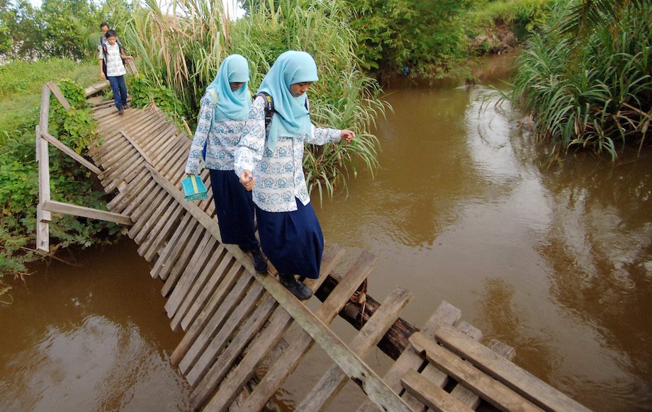 PELAJAR. Pelajar SMP berhati-hati melewati jembatan rusak yang menghubungkan kelurahan Kurao Pagang dengan Dadok, di Padang, Sumatera Barat, Kamis (3/12). Setiap hari anak-anak harus melewati jembatan itu untuk pergi ke sekolah karena jalan lain memutar lebih jauh. ANTARA/Iggoy el Fitra 