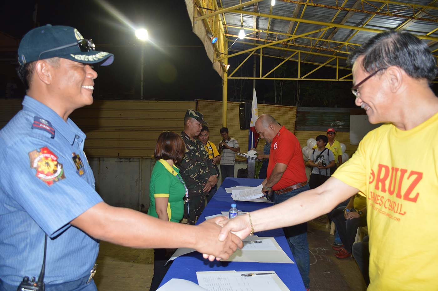 SAFE POLLS. Dipolog City police chief Superintendent Lito Andaya shakes the hand of Liberal Party candidate for councilor James Cyril Ruiz. Photo by Gualberto Laput 