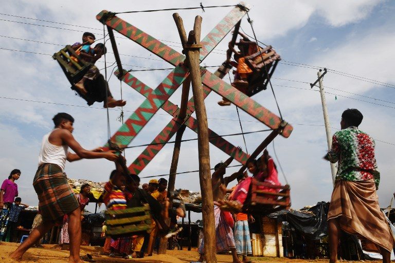 INNOCENCE. Young Rohingya refugees enjoy rides in a traditional wooden ferris wheel during Eid'l Adha festival celebrations at the Kutupalong refugee camp in Ukhia district near Cox's Bazar on August 23, 2018. Photo by Dibyangshu Sarkar/AFP   