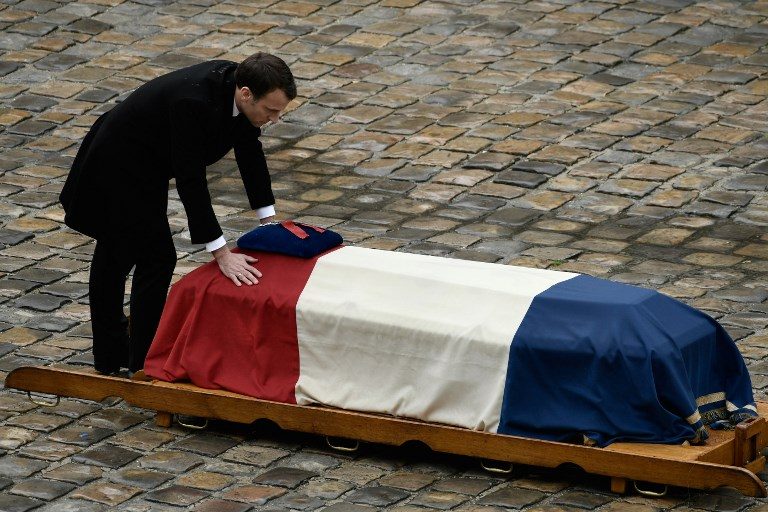 HERO. French President Emmanuel Macron places his hands on the flag-draped coffin of Lieutenant Colonel Arnaud Beltrame after awarding him posthumously with the Legion of Honor on March 28, 2018 at the Hotel des Invalides in Paris. Photo by Philippe Lopez   