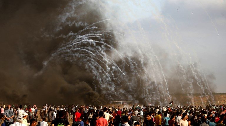 VIOLENT. Palestinian protesters gather as tear gas canisters are launched by Israeli forces during a demonstration along the border between Israel and the Gaza Strip on August 3, 2018. Photo by Mahmud Hams/AFP  