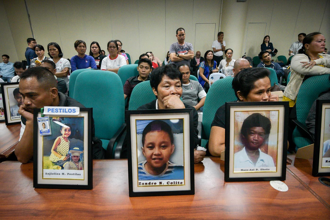 IN GRIEF. Parents of children vaccinated with Dengvaxia bring pictures of their loved ones at a Senate hearing on the controversial government anti-dengue vaccination program on February 21, 2018. Photo by LeAnne Jazul/Rappler    
