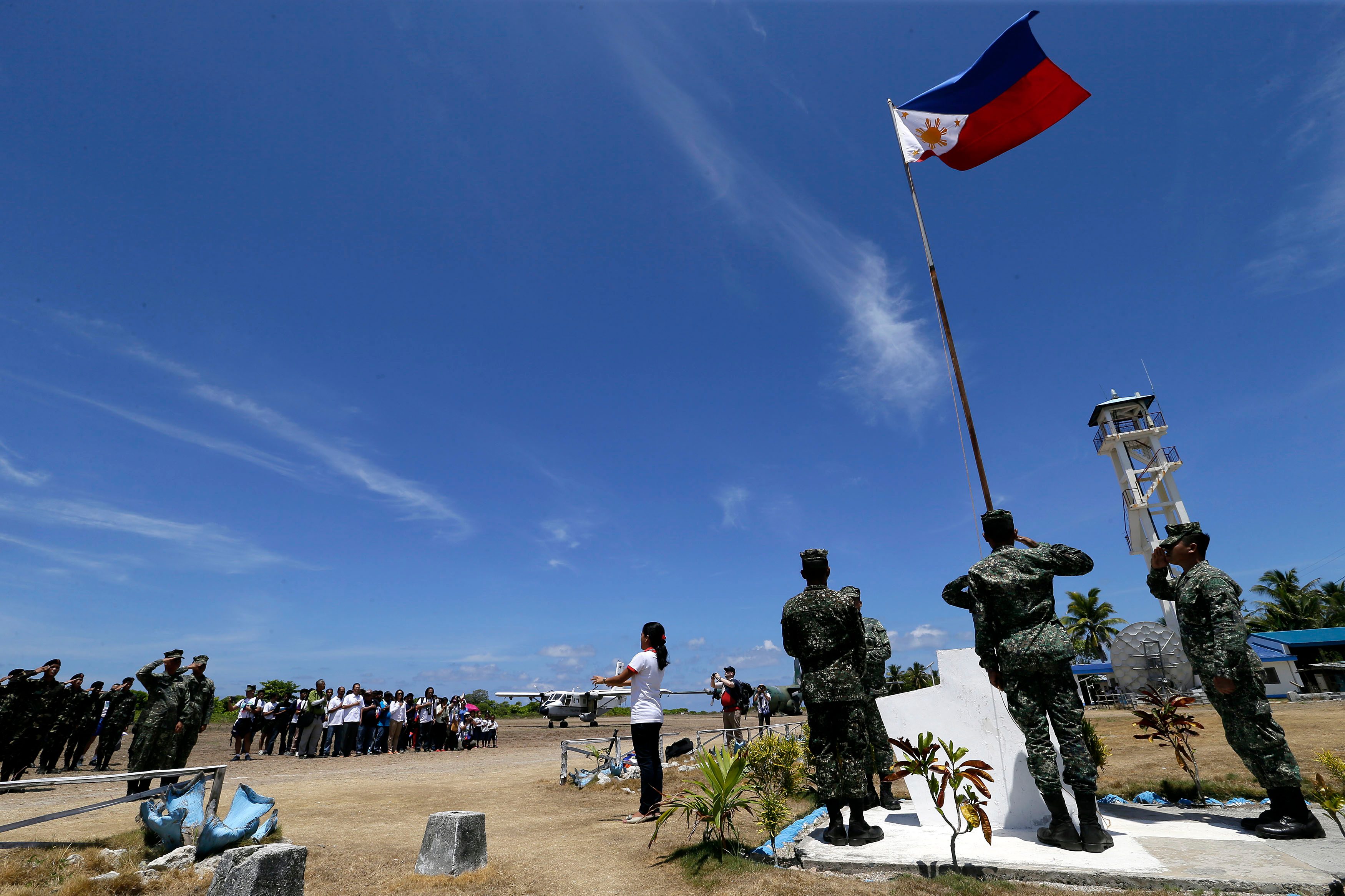 PHILIPPINE FLAG. Filipino residents and soldiers conduct a flag raising ceremony during the visit of Armed Forces of the Philippines military chief General Gregorio Catapang Jr in Pag-asa (Thitu) island on May 11. Photo by Ritchie Tongo/EPA  