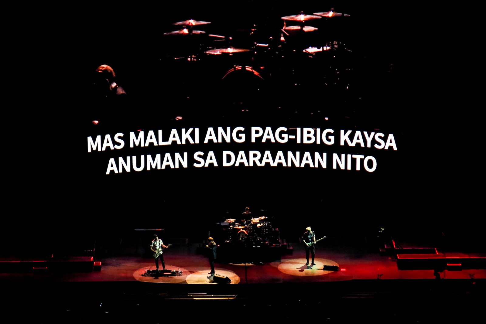 LOVE CONQUERS ALL. The Filipino translation of 'Love is Bigger Than Anything In Its Way' flashed on the screen as the band performs the song. Photo by Mia Gonzalez/Rappler  