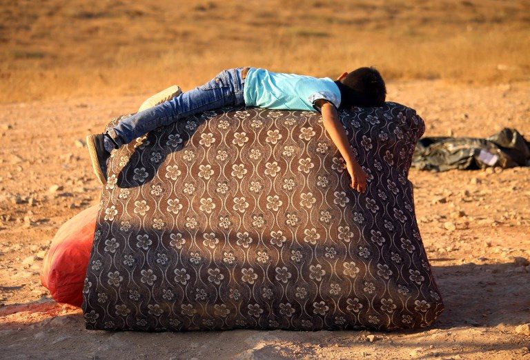 GOING HOME. A Syrian refugee rests on the side of the road as he returns to Syria with his family after crossing the Jordanian border near the town of Nasib, in the southern province of Daraa, on August 29, 2017. Photo by Mohamad Abazeed/AFP  