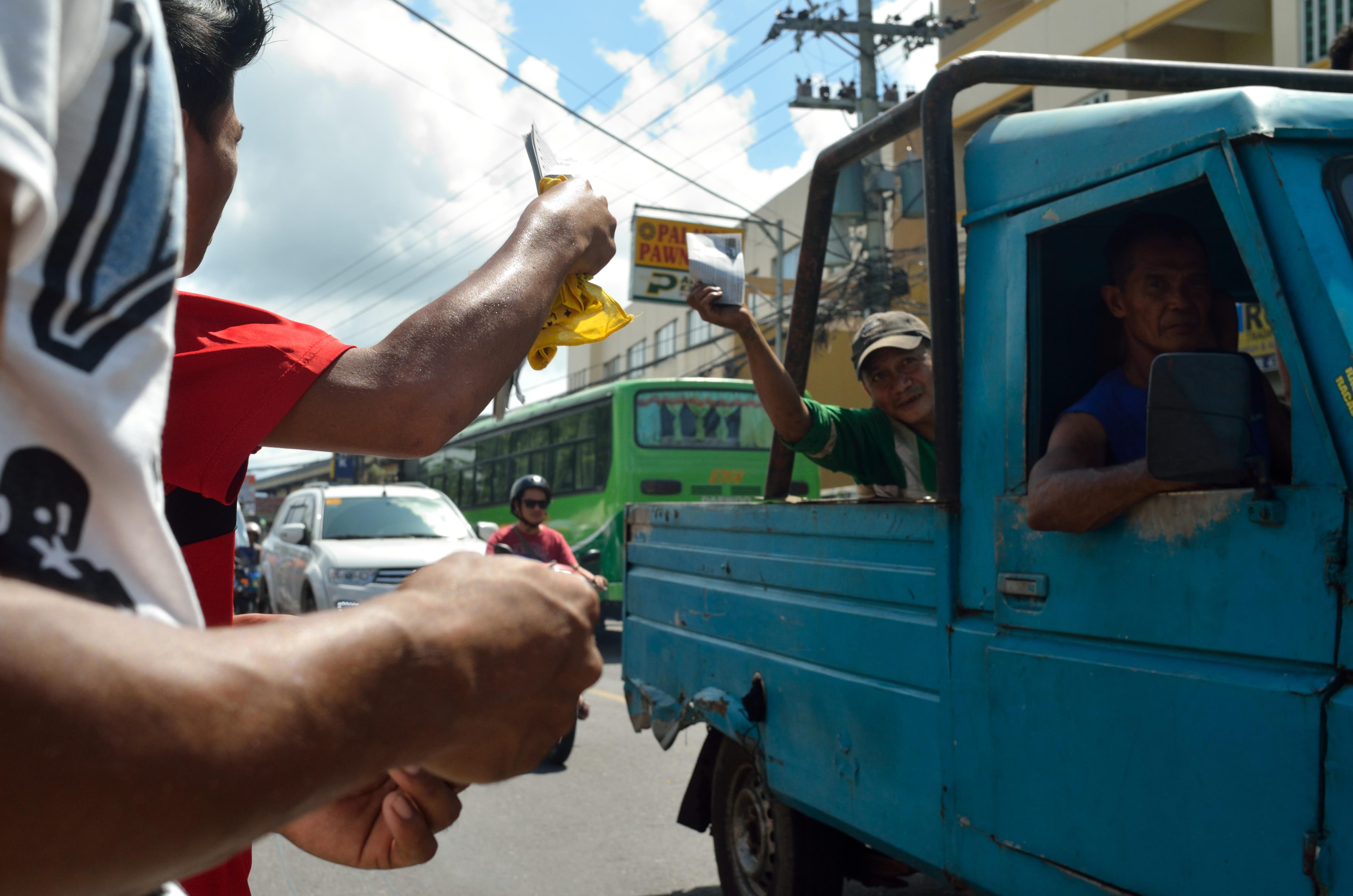 NAGA. Protesters give out pamphlets to passing vehicles. Photo by Miguel Imperial/Rappler 
