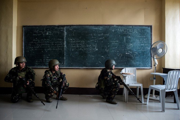 CLASSES SUSPENDED. Philippine Army Scout Rangers crouch in a classroom during a mission to flush out Islamist militant snipers in Marawi on June 6, 2017. Photo by Noel Celis/AFP  
