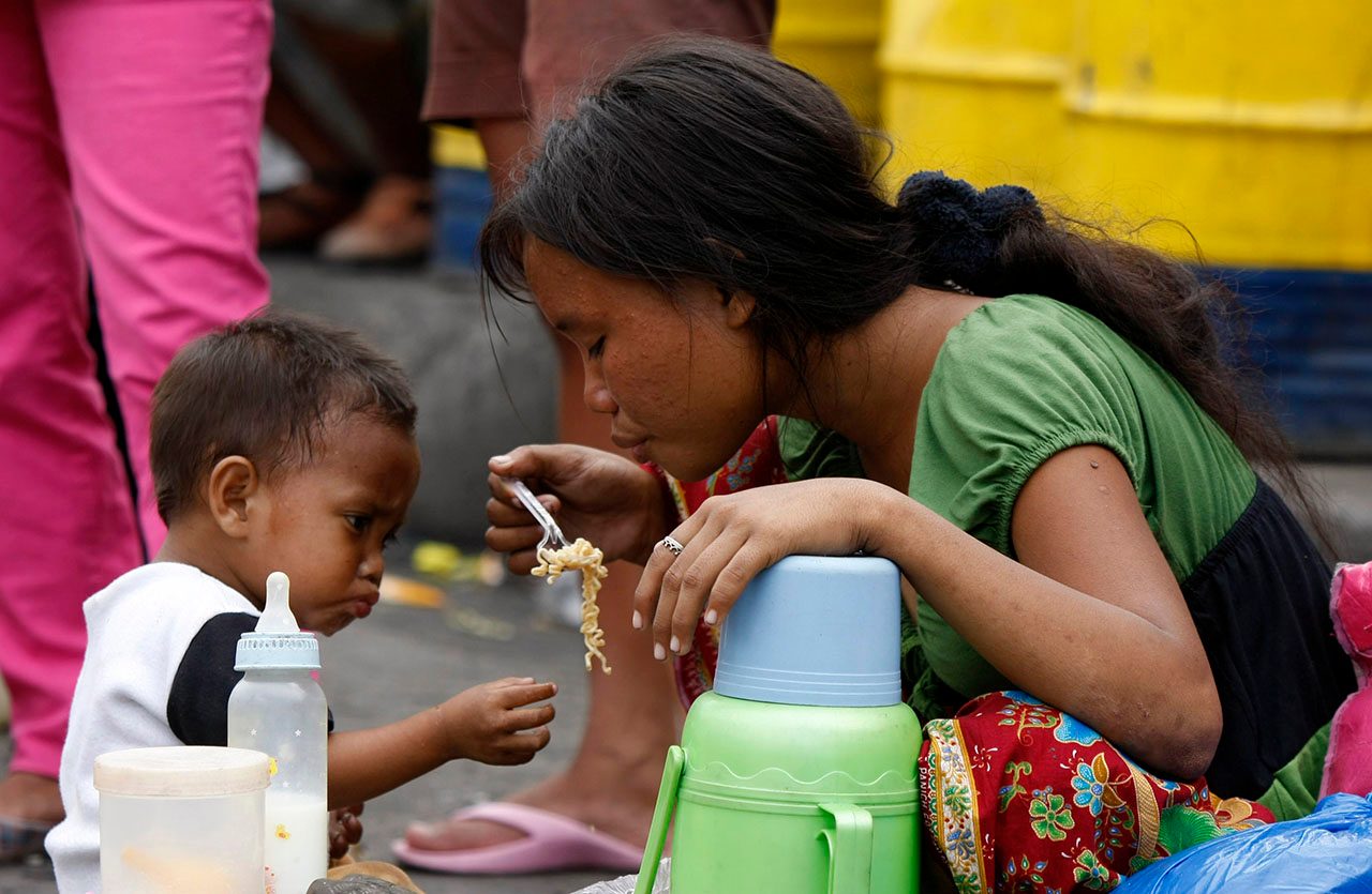 A Filipino mother and her child eat their lunch while waiting for their ship back to their provinces in Port Area, Manila, Philippines on 07 January 2010. Slightly fewer Filipinos look forward to 2010 with hope after experiencing a series of tragedies in 2009, among them epic floods in Metro Manila and Luzon, a survey by the Social Weather Stations (SWS) showed. The survey, conducted from 05 to 10 December 2009, found that while nine out of 10 Filipinos were hopeful, the rate was lower than in the previous three years. Photo by Dennis M. Sabangan/EPA 