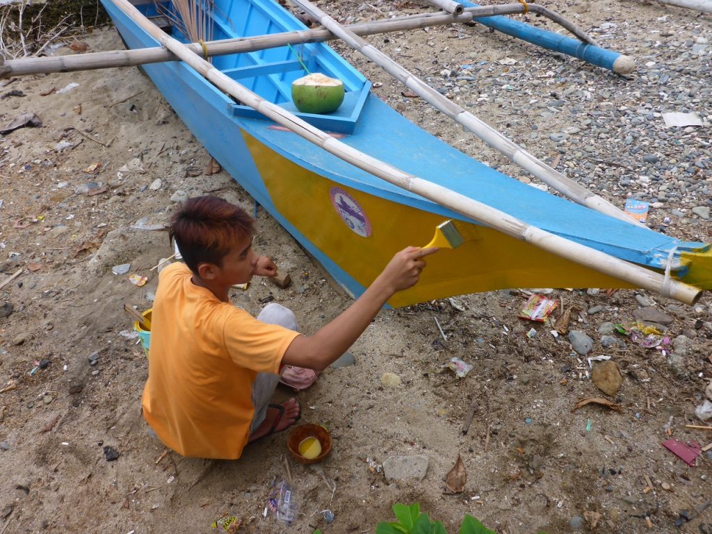 COLOR-CODING. Fisher Jude Nicopior paints the prow of his boat yellow as part of a color-coding scheme to deter encroachment in municipal waters.
Photo by Yasmin Arquiza/Rare
  