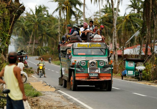 Filipinos ride a jeepney, a popular mode of transport, at a road in the typhoon hit town of San Julian, Samar island, Philippines, 10 December 2014. Typhoon Hagupit slammed into the eastern coast of Samar Island, 560 kilometres south-east of Manila on 06 December, destroying more than 30,000 homes, knocking out power and damaging some key infrastructures. Some roads were impassable due to floods, landslides and toppled trees or electric posts. Photo by Francis R. Malasig/EPA 