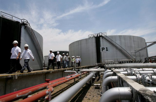 CONTROVERSIAL DEPOT. Filipino Energy officials and oil company workers inspect a biodiesel overhead tank inside the Pandacan Oil depot in this May 2007 file photo. File photo by Dennis M. Sabangan/EPA