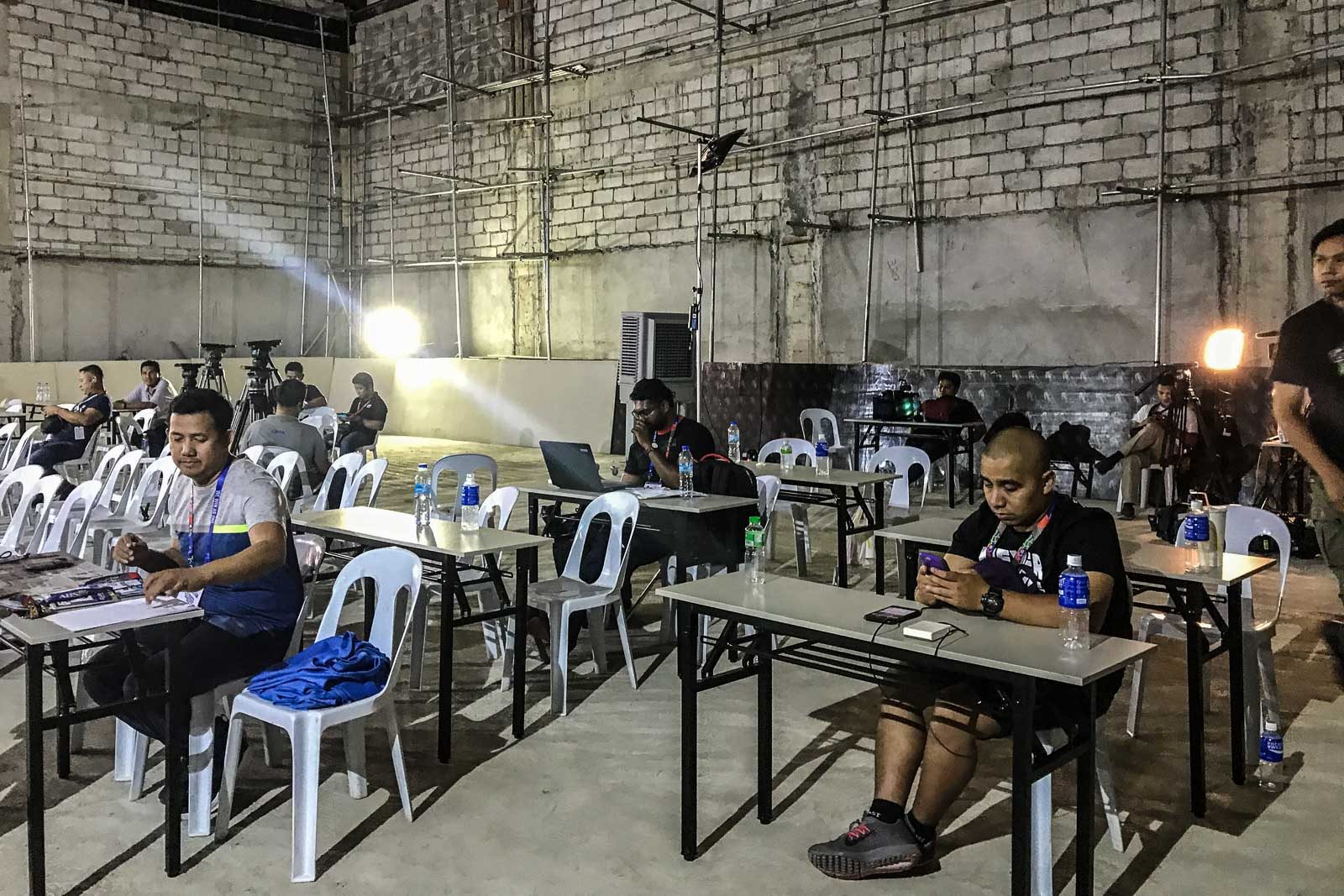 COMPLAINTS. Members of the make do with folding tables and monoblocks at the media center inside the Rizal Memorial Stadium. Photo by Beatrice Go/Rappler  