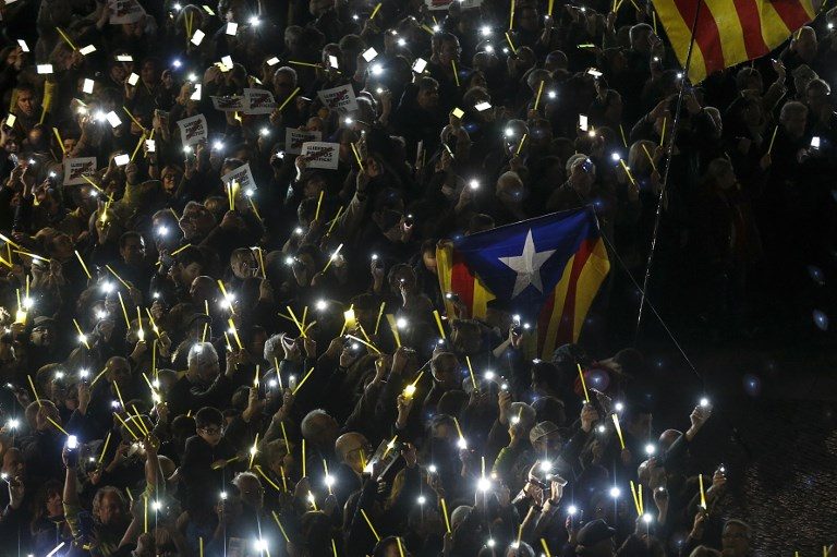 LIGHT FOR INDEPENDENCE. People hold their mobile phones to create the shape of a giant ribbon in front of the 'Generalitat' palace at the Sant Jaume square in Barcelona on November 16, 2017. Photo by Pau Barrena/AFP 