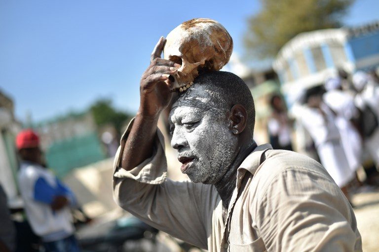 VOODOO. A devotee places a skull on top of his head during ceremonies honoring the Haitian voodoo spirit of Baron Samdi and Gede on the Day of the Dead in the Cementery of Cite Soleil, in Port-au-Prince, Haiti on November 1, 2017. Photo by Hector Retamal/AFP   