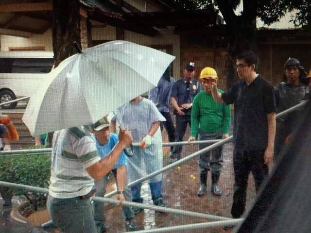 BARRICADED. Angel Manalo confronts workers building the fences inside the Tandang Sora compound on December 15.   