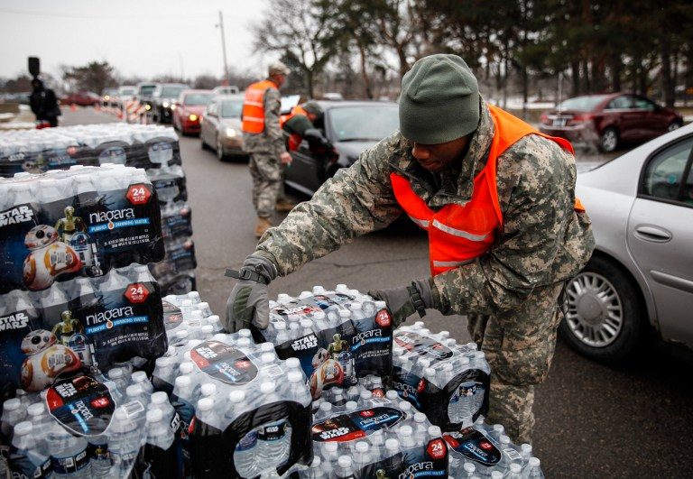 EMERGENCY WATER. Army National Guard Specialist David Brown loads bottled water into waiting cars at a fire station on January 21, 2016 in Flint, Michigan. Sarah Rice/Getty Images/AFP 
