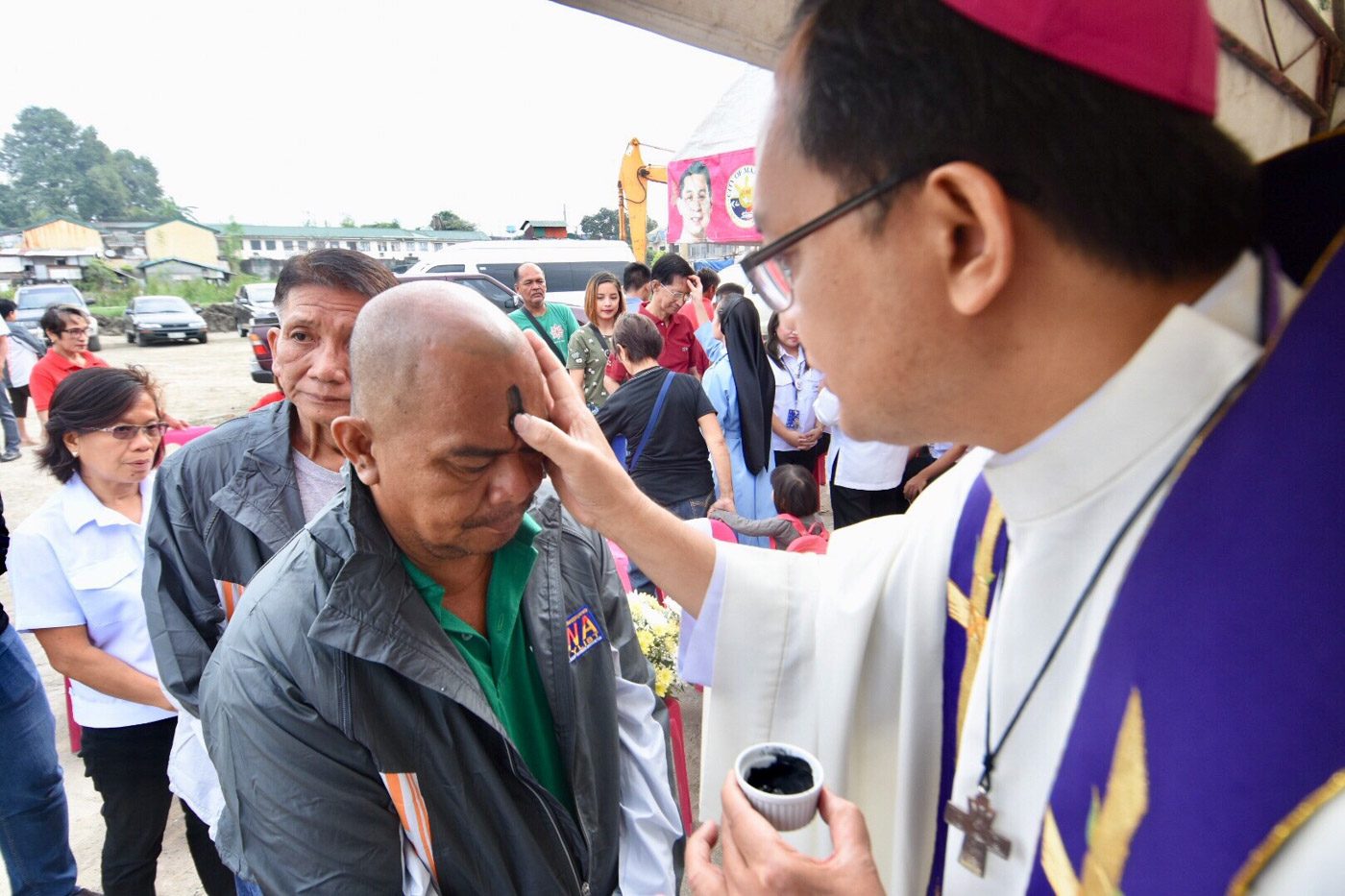 ASH WEDNESDAY. Caloocan Bishop Pablo Virgilio David marks foreheads with ashes during the Ash Wednesday Mass on February 14, 2018, in a relocation site in Malabon. Photo by Angie de Silva/Rappler 