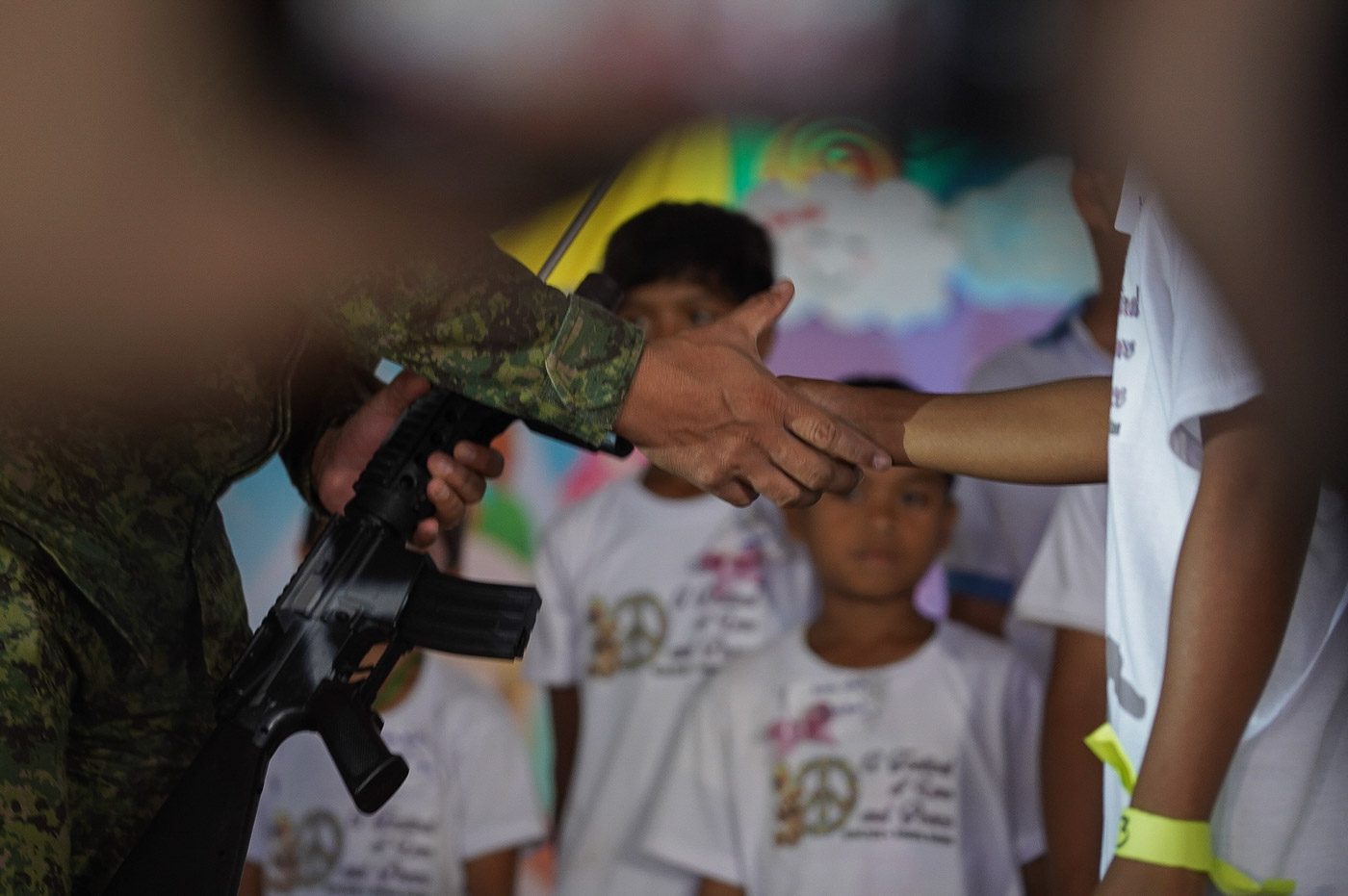 SUPPORT FOR PEACE. A military officer shakes the hand of a child who had just turne over a toy gun, symbolic of the Basilan youth's support for peace in the region 