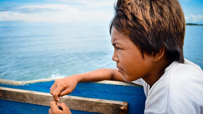AH, YOUTH. The son of our boatman keeps an eye on the sea as we sail toward Lampinigan Island
