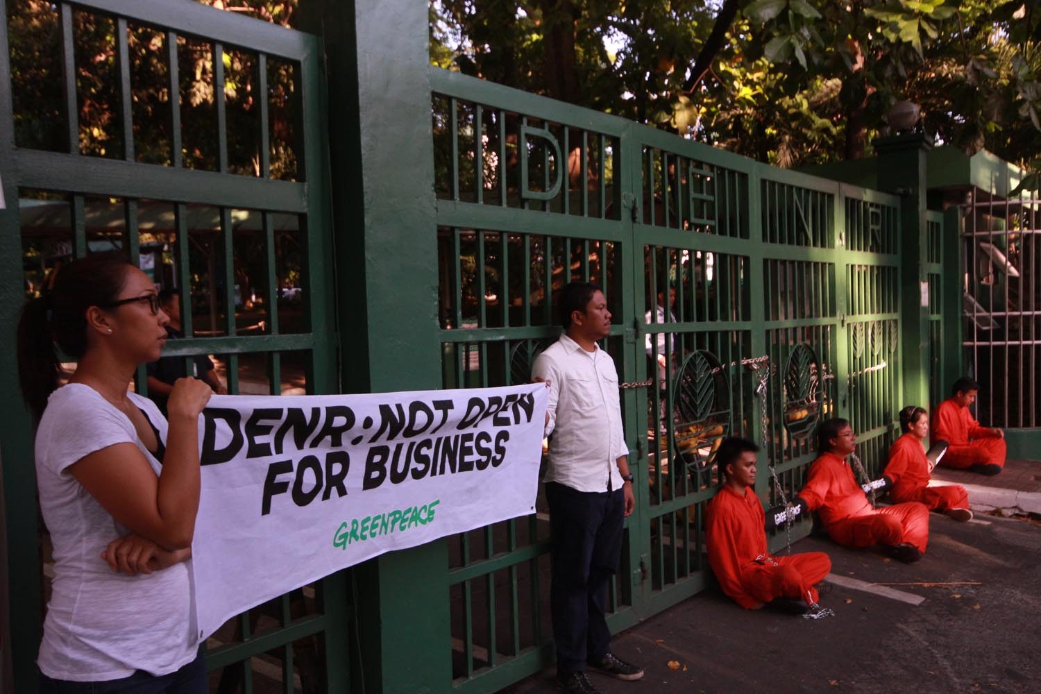NOT OPEN. Activists from Greenpeace Philippines chain themselves to the gates of the Department of Environment and Natural Resources office in Quezon City on May 8, 2017 to call out the Duterte administration for allegedly bowing to big corporate interests. Photo by Darren Langit/Rappler
   