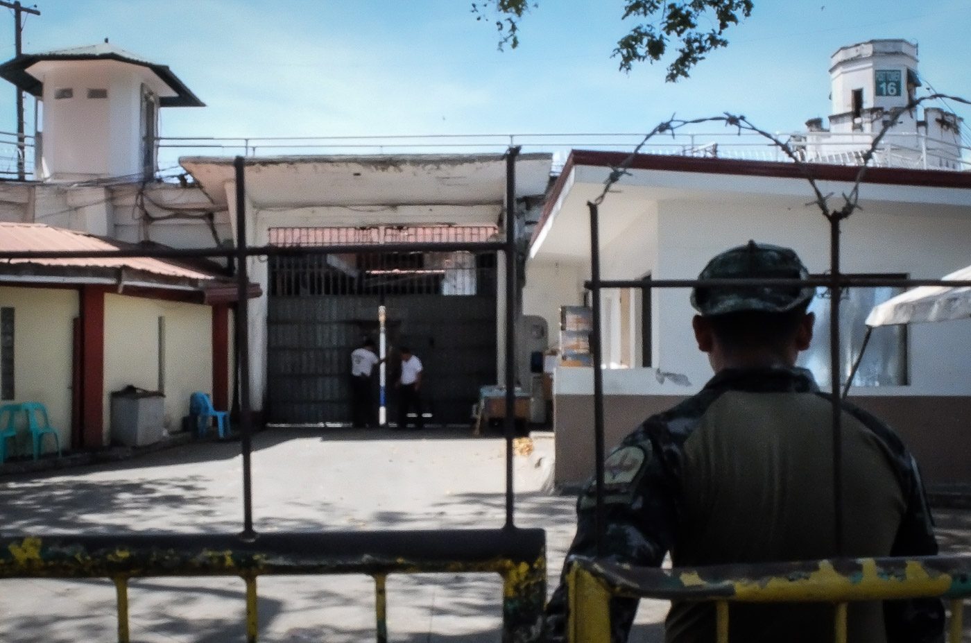 STRICT SECURITY. A member of the PNP-SAF guards one of the gates of the New Bilibid Prison. Photo by LeAnne Jazul/Rappler  