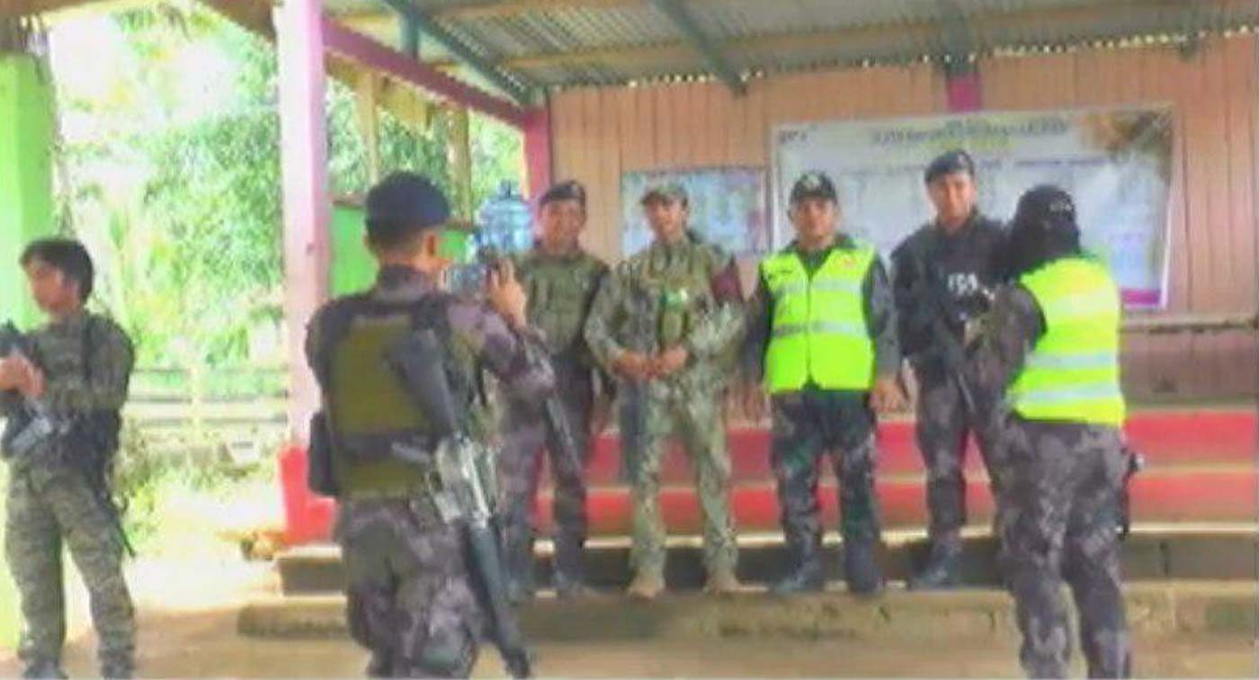 PHOTO OP. A local cop in a neon green vest stands as MILF men take a photo with him in the registration.  