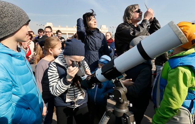 CURIOUS CROWD. Russian people watch a solar eclipse through a telescope in Moscow, Russia, March 20, 2015. Yuri Kochetkov/EPA 