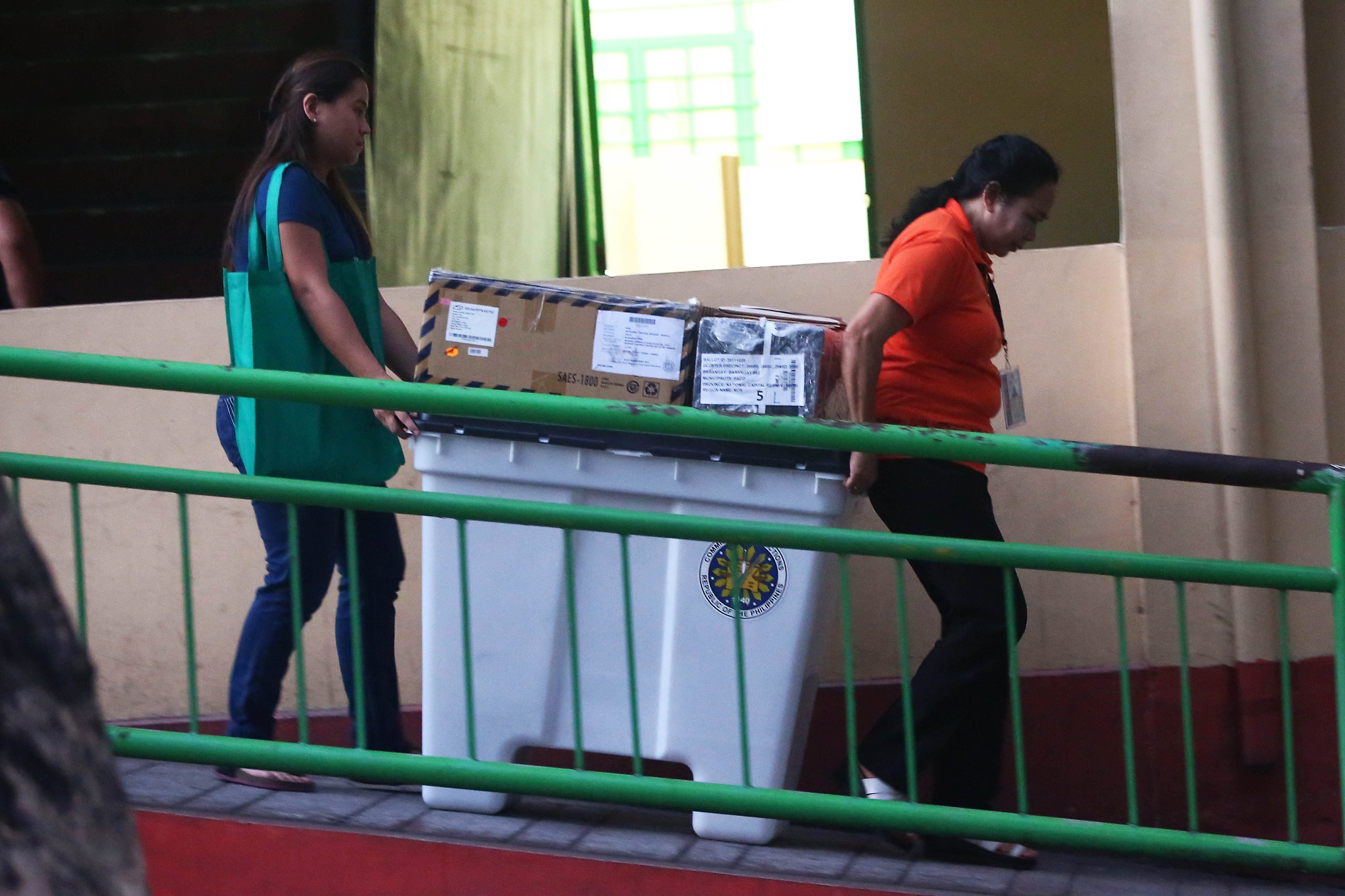 GETTING READY. Teachers carry election paraphernalia as they prepare for the election at the Araullo High School in Manila. Photo by Ben Nabong/Rappler  