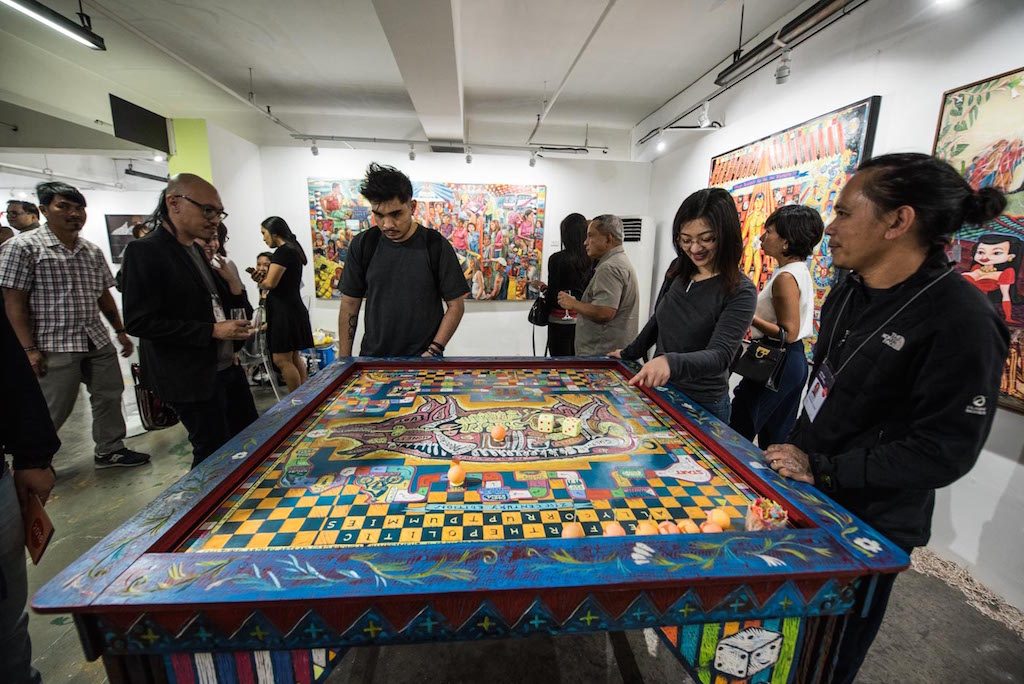PLAYFUL. Viewers interact with one of the central pieces in Leonard Aguinaldo's exhibit: a board game. Photo by Alecs Ongcal/Rappler 